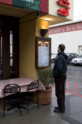 Man looking at menu in front of restaurant at fisherman's wharf.jpg